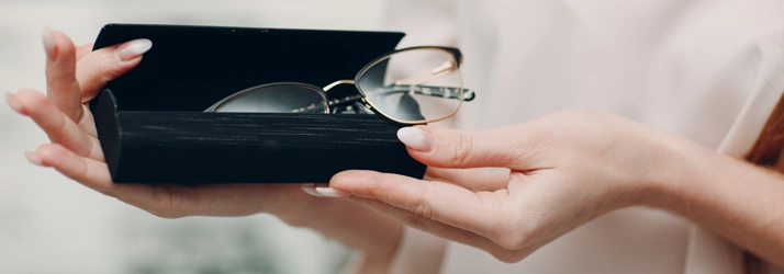 Eye Doctor Sault Ste. Marie MI Glasses A person holding an eye glasses case with glasses hanging out.
