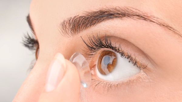 Eye Doctor Sault Ste. Marie MI Person With Contact A person holding a contact up to their eye.