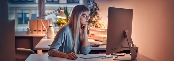 A woman sitting in front of a computer screen.