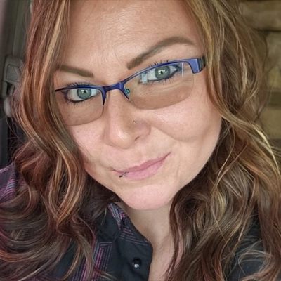 Sammi Jo wearing glasses smirking at camera